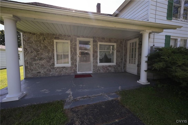 202 County Highway 25a, Richfield, NY 13439 - doorway to property featuring stone siding, a chimney, and a patio area