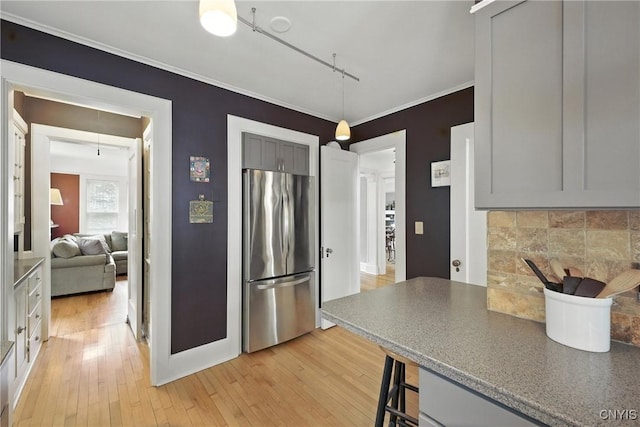 306 Berkeley Dr, Syracuse, NY 13210 - kitchen with freestanding refrigerator, backsplash, light wood finished floors, a breakfast bar area, and ornamental molding
