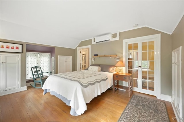 306 Berkeley Dr, Syracuse, NY 13210 - bedroom with french doors, vaulted ceiling, a wall mounted AC, and wood finished floors