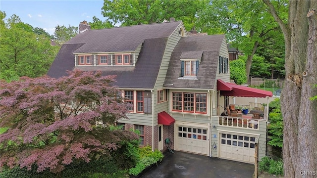 306 Berkeley Dr, Syracuse, NY 13210 - view of front of home featuring asphalt driveway, a gambrel roof, a garage, and a chimney
