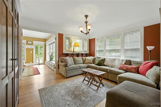 306 Berkeley Dr, Syracuse, NY 13210 - living room featuring light wood-type flooring, plenty of natural light, a chandelier, and radiator