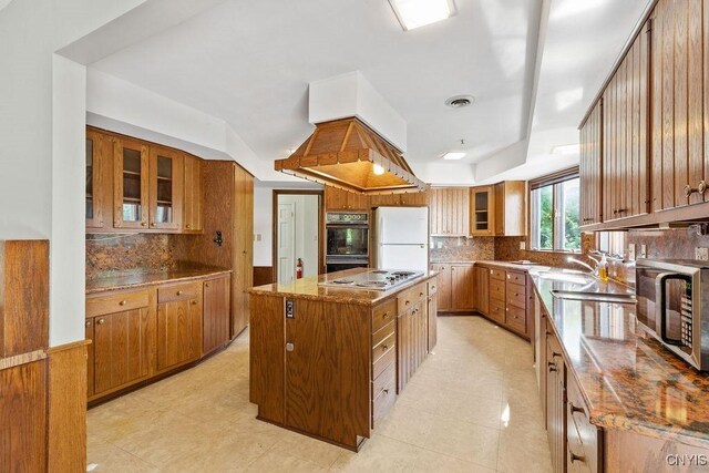 20 Cross Rd, Dewitt, NY 13224 - kitchen with freestanding refrigerator, stainless steel microwave, a kitchen island, and brown cabinetry