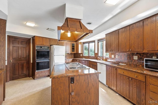 20 Cross Rd, Dewitt, NY 13224 - kitchen with dishwasher, stainless steel stovetop, tasteful backsplash, brown cabinets, and a center island