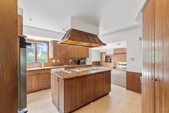 20 Cross Rd, Dewitt, NY 13224 - kitchen with stainless steel appliances, brown cabinets, open floor plan, light tile patterned flooring, and a wainscoted wall