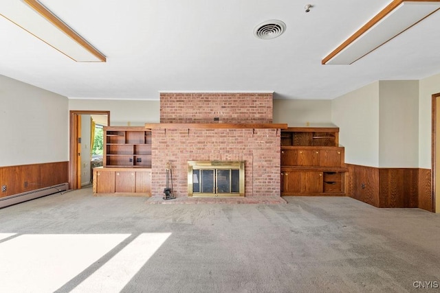 20 Cross Rd, Dewitt, NY 13224 - unfurnished living room featuring wainscoting, carpet flooring, wood walls, baseboard heating, and a brick fireplace