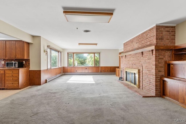 20 Cross Rd, Dewitt, NY 13224 - unfurnished living room featuring a wainscoted wall, carpet flooring, a fireplace, wood walls, and a baseboard radiator