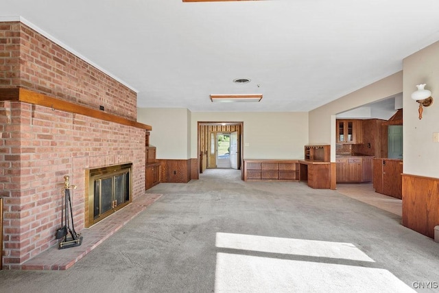 20 Cross Rd, Dewitt, NY 13224 - unfurnished living room with a wainscoted wall, light colored carpet, wood walls, and a fireplace