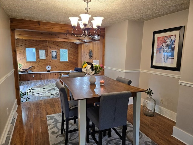 211 Steko Ave, Rochester, NY 14615 - dining space featuring wooden walls, wood finished floors, a chandelier, and a textured ceiling