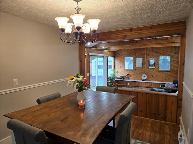 211 Steko Ave, Rochester, NY 14615 - dining space with wood finished floors, a chandelier, wood walls, a textured ceiling, and beam ceiling