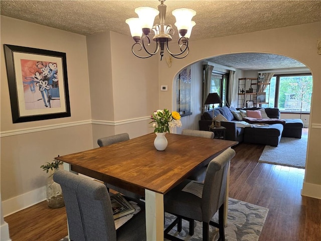 211 Steko Ave, Rochester, NY 14615 - dining space featuring arched walkways, a chandelier, dark wood-type flooring, and a textured ceiling