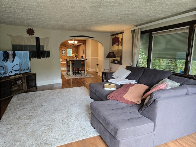 211 Steko Ave, Rochester, NY 14615 - living room with arched walkways, wood finished floors, a textured ceiling, and a chandelier