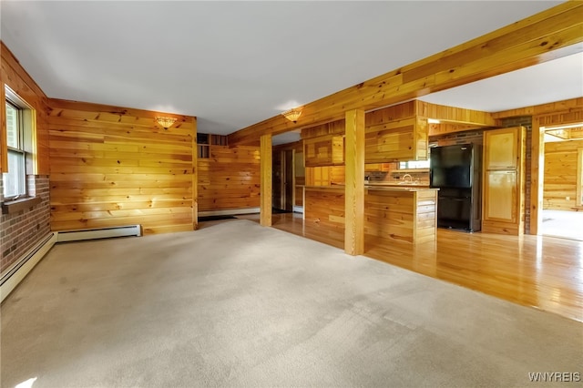 1520 Davis Rd, Aurora, NY 14170 - unfurnished living room featuring wood walls, a baseboard radiator, light colored carpet, and light wood finished floors