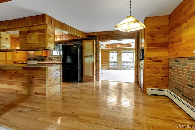1520 Davis Rd, Aurora, NY 14170 - kitchen featuring freestanding refrigerator, wood walls, light wood finished floors, hanging light fixtures, and a peninsula