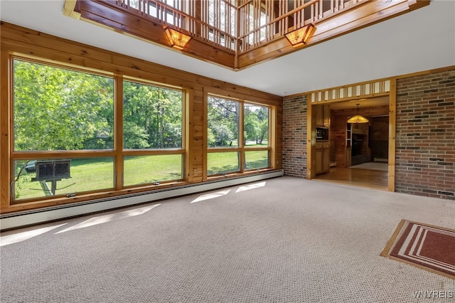 1520 Davis Rd, Aurora, NY 14170 - unfurnished living room featuring carpet flooring, wood walls, and a baseboard heating unit