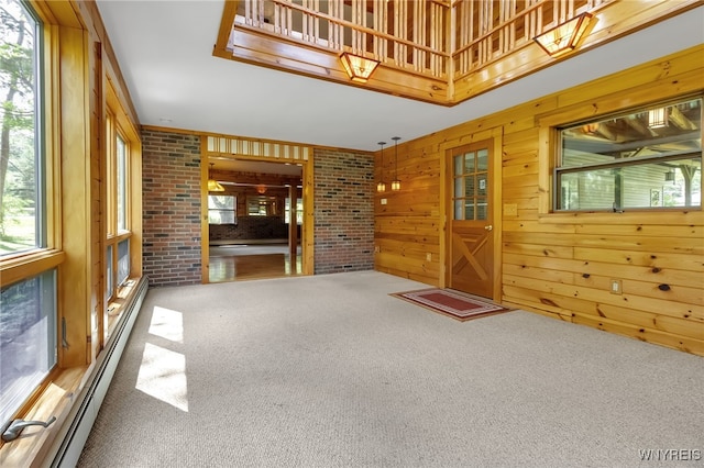 1520 Davis Rd, Aurora, NY 14170 - unfurnished living room with carpet floors, a baseboard heating unit, and wooden walls