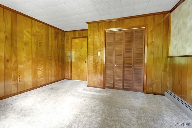1520 Davis Rd, Aurora, NY 14170 - unfurnished bedroom featuring a baseboard heating unit, carpet flooring, a closet, wooden walls, and ornamental molding