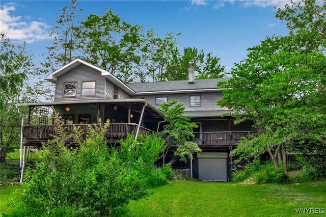 1520 Davis Rd, Aurora, NY 14170 - rear view of property featuring a sunroom, a deck, a garage, and a yard