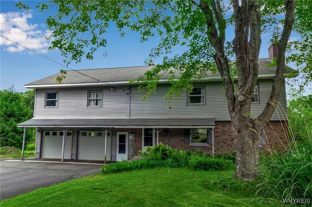 1520 Davis Rd, Aurora, NY 14170 - view of front of home with a front lawn, brick siding, an attached garage, asphalt driveway, and a chimney
