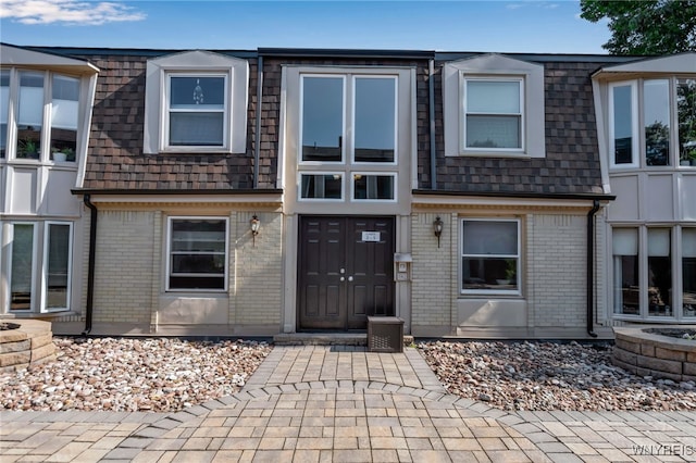 32 Bernhardt Dr Unit 5, Amherst, NY 14226 - view of front facade with mansard roof, brick siding, and roof with shingles