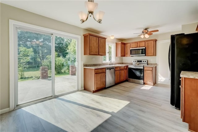 3245 Culver Rd, Irondequoit, NY 14622 - kitchen featuring stainless steel appliances, brown cabinets, light countertops, and light wood-type flooring