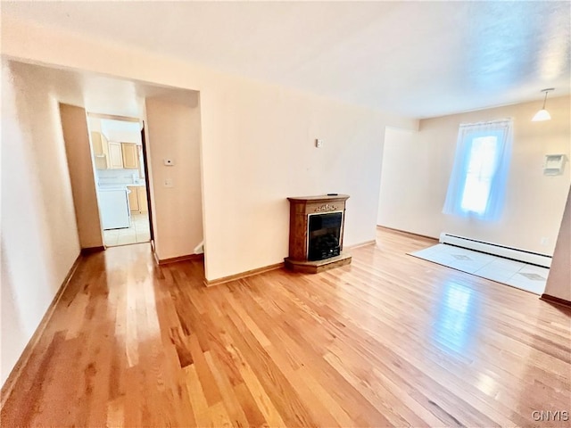 23 Burden Dr, Oswego, NY 13126 - unfurnished living room featuring a baseboard heating unit, light wood-style flooring, and a fireplace