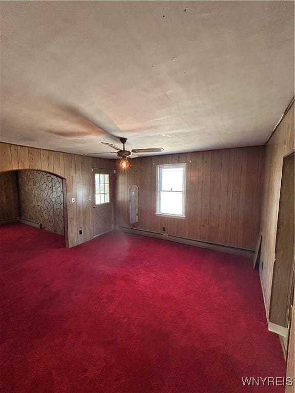 83 Felton St, North Tonawanda, NY 14120 - spare room featuring wood walls, a ceiling fan, baseboard heating, and carpet floors