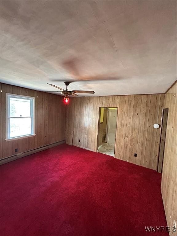 83 Felton St, North Tonawanda, NY 14120 - carpeted empty room with ceiling fan, wooden walls, and a baseboard heating unit