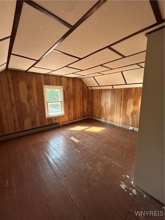 83 Felton St, North Tonawanda, NY 14120 - bonus room with a baseboard heating unit, wood walls, and dark wood finished floors