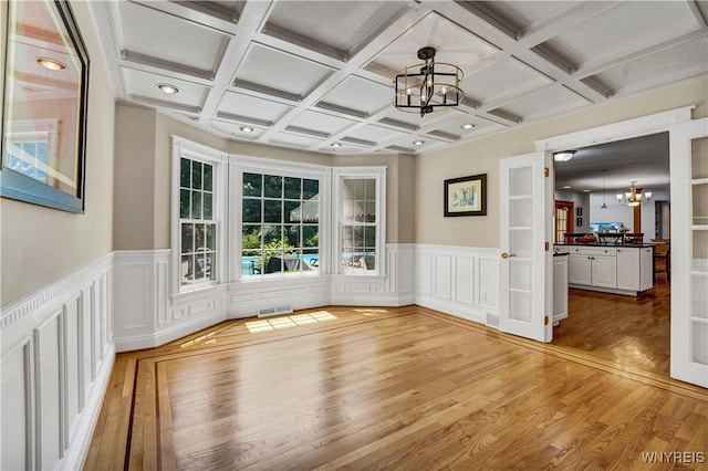 57 Middlebury Rd, Orchard Park, NY 14127 - unfurnished room featuring a chandelier, light wood-style flooring, beam ceiling, coffered ceiling, and wainscoting