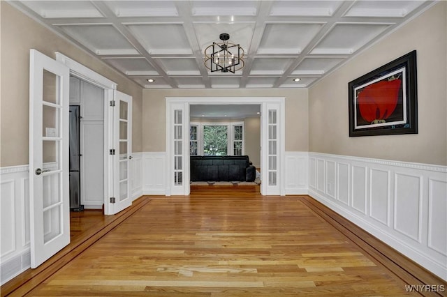 57 Middlebury Rd, Orchard Park, NY 14127 - hall with french doors, light wood finished floors, a chandelier, coffered ceiling, and a wainscoted wall