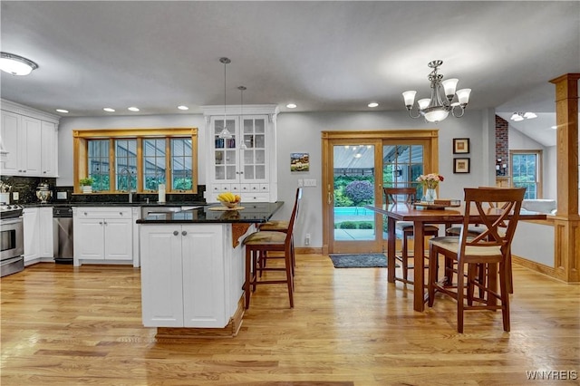 57 Middlebury Rd, Orchard Park, NY 14127 - kitchen with white cabinets, light wood finished floors, stainless steel electric stove, tasteful backsplash, and a kitchen bar
