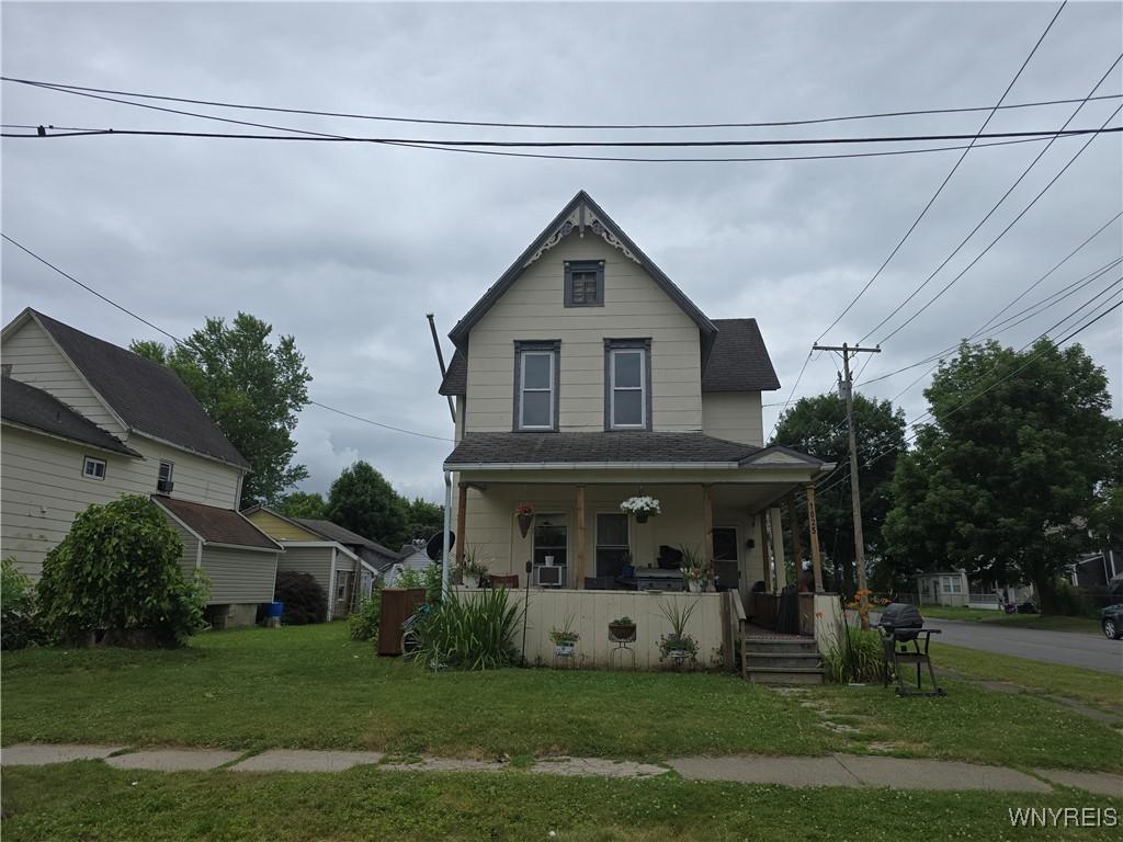 1025 Spruce St, Olean, NY 14760 - victorian home featuring covered porch, a front yard, and roof with shingles