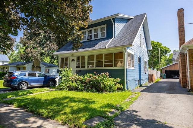 147 Springfield Ave, Rochester, NY 14609 - bungalow-style home featuring an outbuilding, roof with shingles, a detached garage, and a front yard