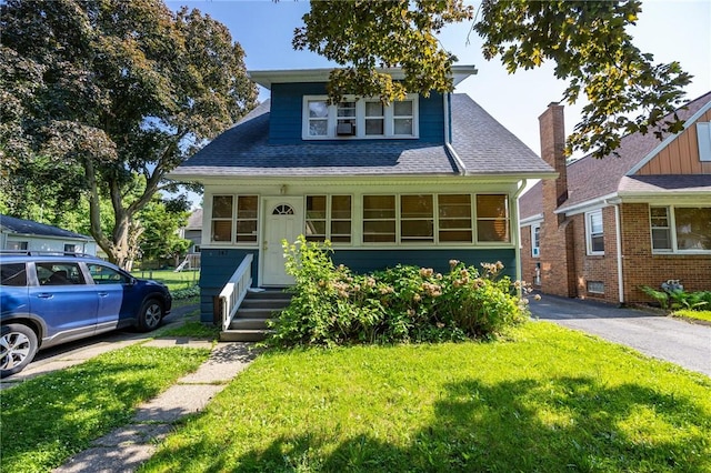 147 Springfield Ave, Rochester, NY 14609 - bungalow-style home featuring a front yard and a shingled roof