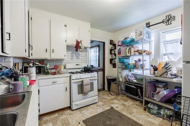 147 Springfield Ave, Rochester, NY 14609 - kitchen featuring white gas range oven, white cabinets, light countertops, and backsplash