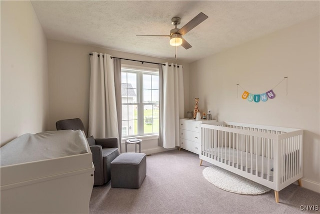 3427 Tall Tree Ln, Lysander, NY 13027 - bedroom with carpet flooring, a nursery area, a ceiling fan, and a textured ceiling
