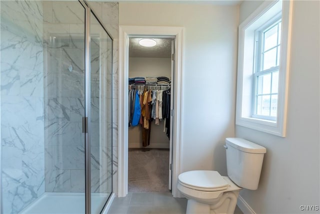 3427 Tall Tree Ln, Lysander, NY 13027 - bathroom featuring a marble finish shower, a spacious closet, and tile patterned flooring