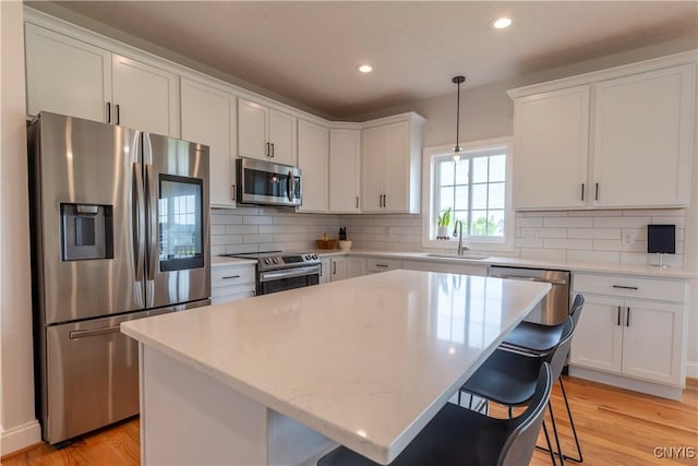 3427 Tall Tree Ln, Lysander, NY 13027 - kitchen featuring appliances with stainless steel finishes, white cabinets, light wood finished floors, backsplash, and recessed lighting