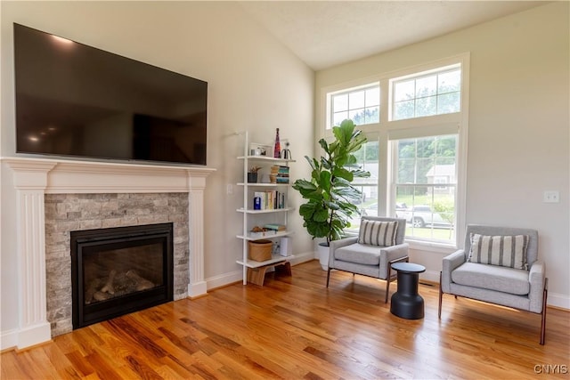 3427 Tall Tree Ln, Lysander, NY 13027 - living area featuring healthy amount of natural light, a fireplace, wood finished floors, and lofted ceiling