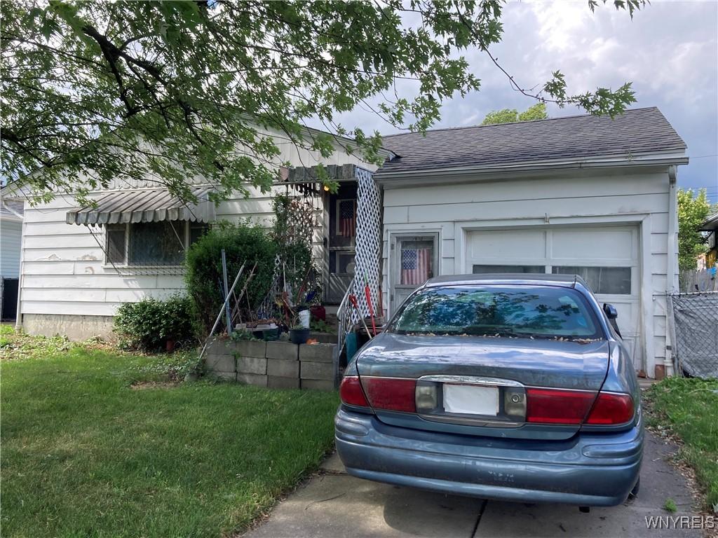 135 Thurston Ave, Tonawanda, NY 14217 - view of front of house with roof with shingles, a garage, and a front lawn