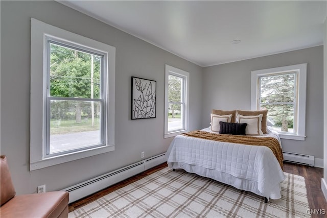 713 Parham St, Wilna, NY 13619 - bedroom featuring a baseboard heating unit, multiple windows, and wood finished floors