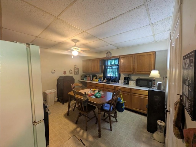 10 Mcclellan Ave, Mount Jewett Boro, PA 16740 - kitchen featuring freestanding refrigerator, a drop ceiling, light floors, and brown cabinetry
