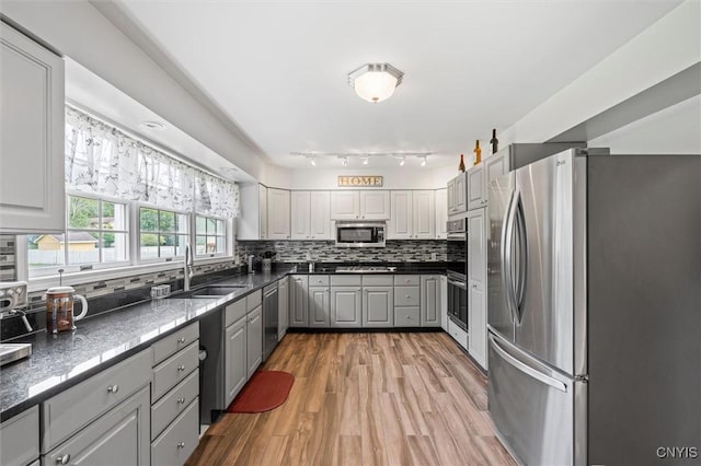 331 Hickory Ln, Hastings, NY 13036 - kitchen with stainless steel appliances, gray cabinets, dark countertops, tasteful backsplash, and light wood finished floors