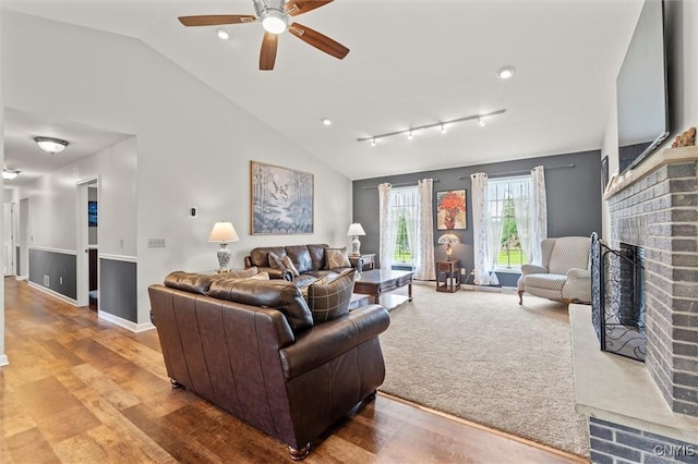 331 Hickory Ln, Hastings, NY 13036 - living area featuring a brick fireplace, ceiling fan, vaulted ceiling, wood finished floors, and track lighting