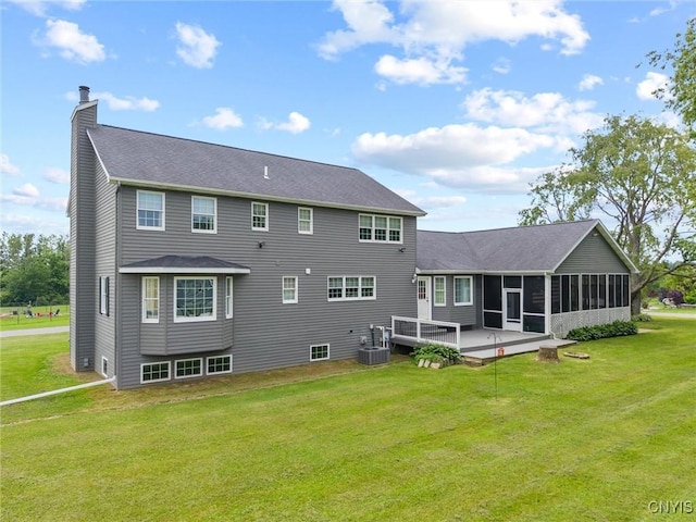 331 Hickory Ln, Hastings, NY 13036 - back of property with a chimney, a sunroom, a lawn, a deck, and roof with shingles