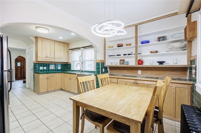 108 Iroquois St, Rochester, NY 14609 - kitchen featuring light brown cabinetry, light tile patterned floors, backsplash, open shelves, and arched walkways