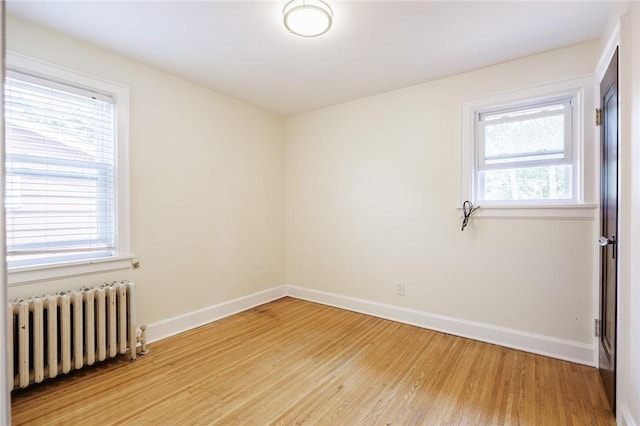 108 Iroquois St, Rochester, NY 14609 - empty room with radiator heating unit, light wood-style flooring, and plenty of natural light