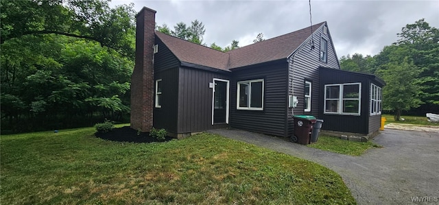 76 Deacon Rd, Orchard Park, NY 14127 - view of front of house featuring a shingled roof, a front lawn, and a chimney