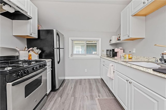 1084 Plymouth Ave S, Rochester, NY 14608 - kitchen with stainless steel appliances, under cabinet range hood, white cabinets, light wood-style flooring, and vaulted ceiling