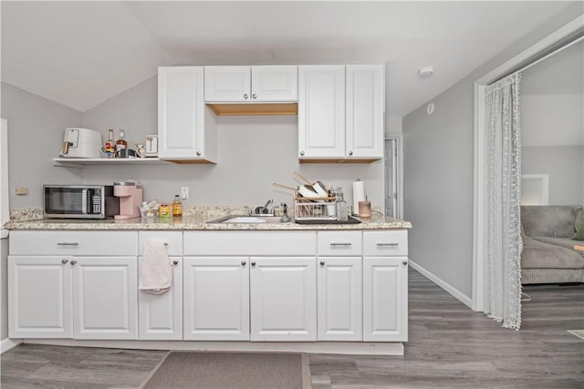 1084 Plymouth Ave S, Rochester, NY 14608 - kitchen featuring stainless steel microwave, white cabinetry, wood finished floors, open shelves, and vaulted ceiling